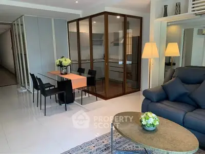 Spacious modern living room with elegant dining area and glass-enclosed kitchen, perfect for stylish urban living.