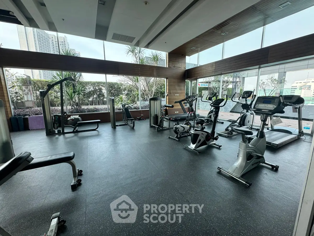 Spacious modern gym with state-of-the-art equipment and panoramic city views, perfect for fitness enthusiasts.