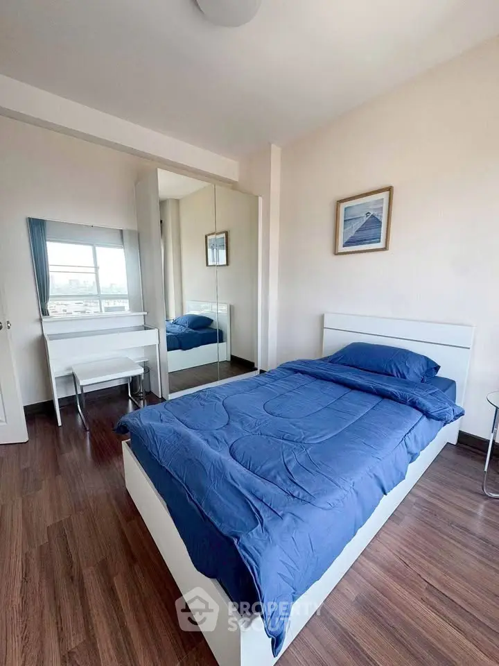 Cozy bedroom with blue bedding and mirrored wardrobe in modern apartment