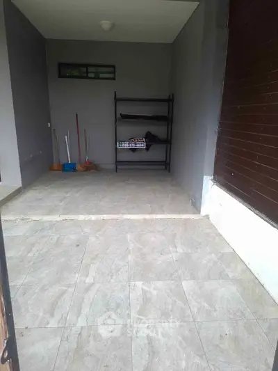 Spacious garage with tiled flooring and storage rack, ideal for parking and organization.