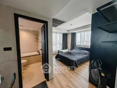 Modern studio apartment with bedroom and bathroom, featuring large windows and sleek design.