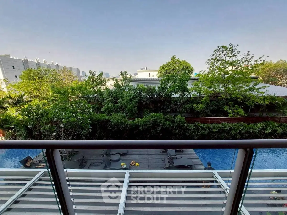 Luxurious balcony view overlooking serene pool and lush greenery, perfect for relaxation and leisure.