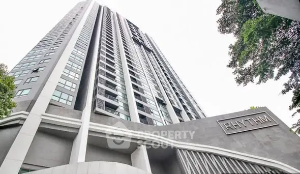 Modern high-rise building with sleek architecture and prominent signage, ideal for urban living.