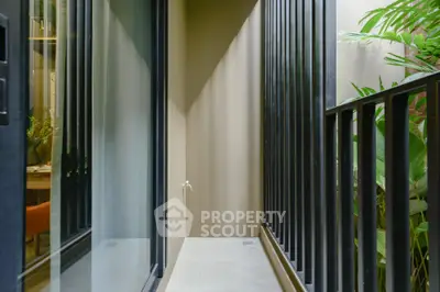Modern narrow balcony with sleek railing and lush greenery