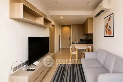 Modern living room with sleek furniture and open kitchen layout in a stylish apartment.