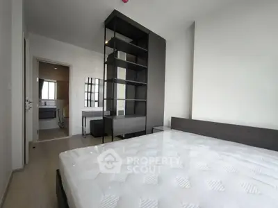 Modern bedroom with minimalist design and large window for natural light.