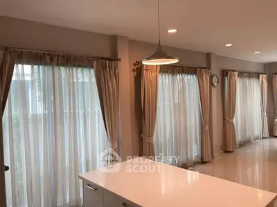 Spacious modern living room with elegant curtains and ample natural light.