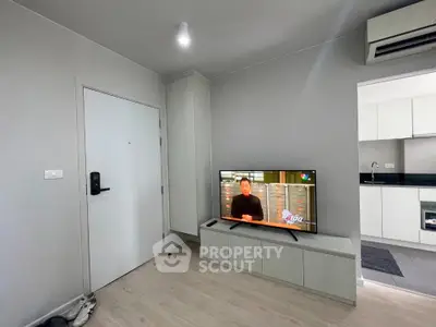 Modern living room with sleek TV setup and open kitchen layout