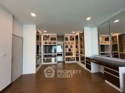 Spacious modern study room with built-in shelves and sleek wooden flooring.