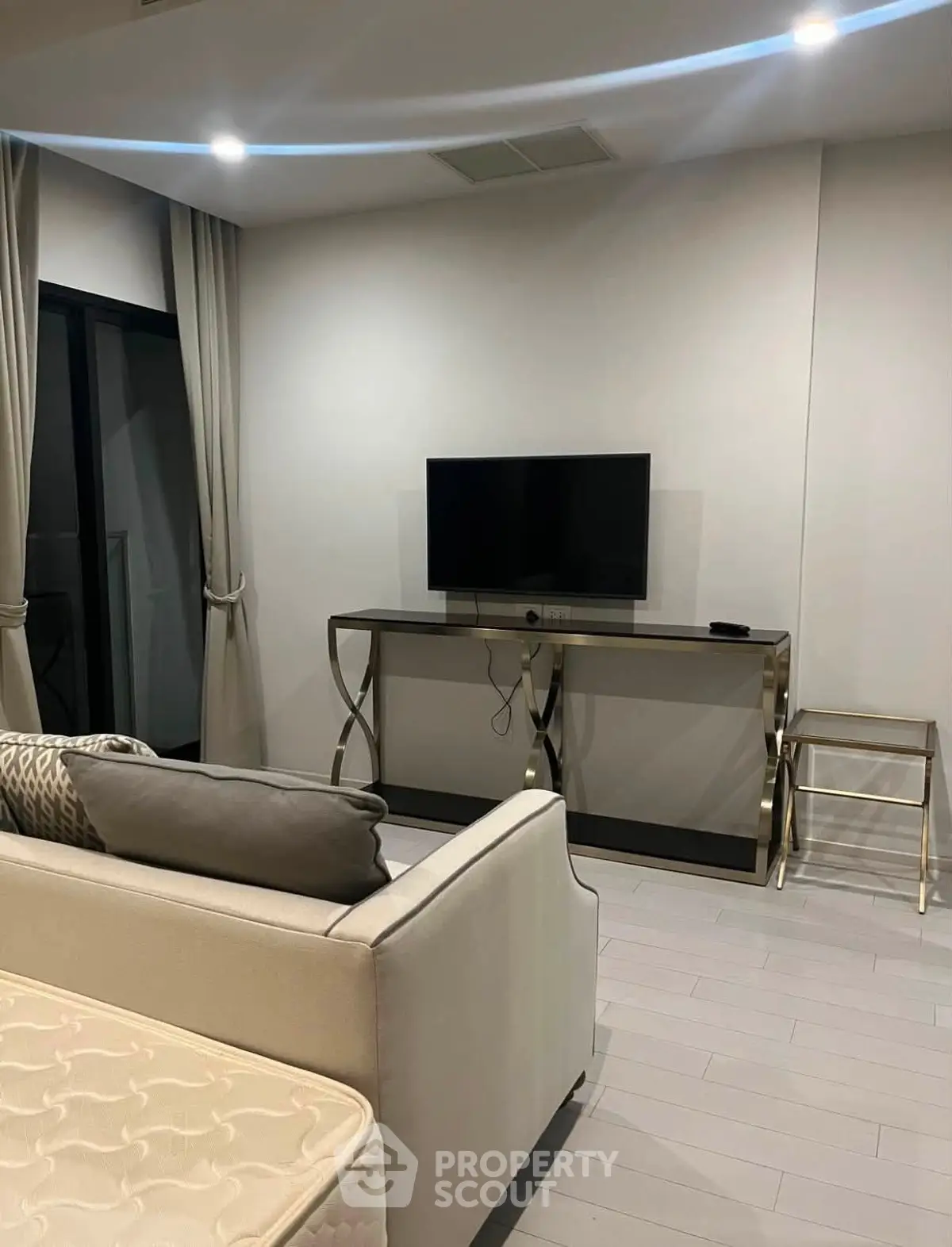 Modern living room with sleek TV setup and elegant furniture in a stylish apartment.