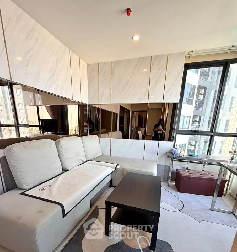 Modern living room with stylish decor and large windows offering city views
