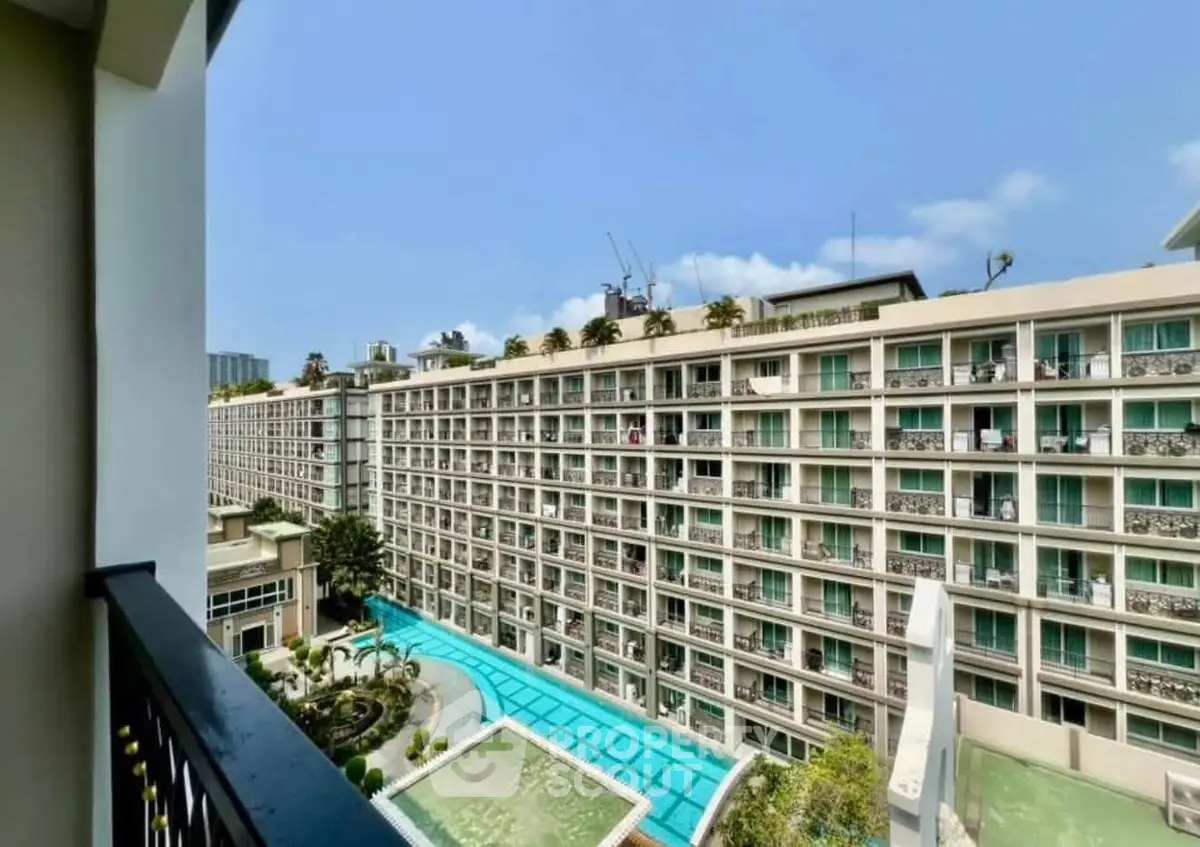 Stunning view of modern apartment complex with pool and lush greenery.