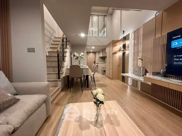 Modern open-plan living room with stylish decor and wooden flooring in a contemporary apartment.