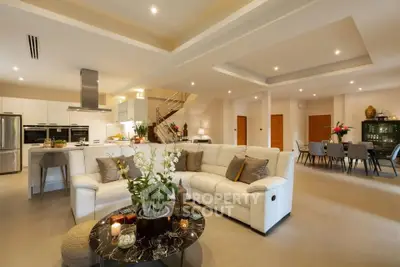 Luxurious open-plan living room with modern kitchen and elegant dining area, perfect for entertaining.