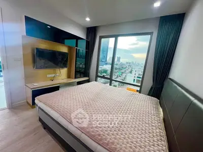 Modern bedroom with city view and wall-mounted TV in a high-rise apartment.