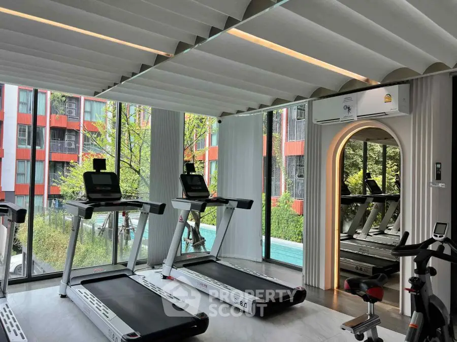 Modern gym with treadmills and mirrored wall in luxury apartment complex