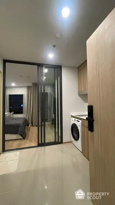 Modern apartment interior with washing machine and cozy bedroom view