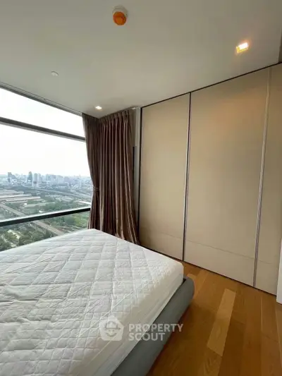 Spacious bedroom with city view and modern design in high-rise apartment