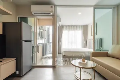 Modern studio apartment with open layout, featuring a cozy living area, compact kitchen, and bright bedroom.