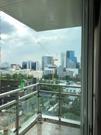 Stunning city view from a modern apartment balcony with glass railing.