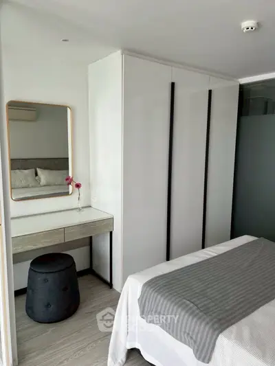 Modern bedroom with sleek wardrobe and stylish vanity in a cozy apartment.