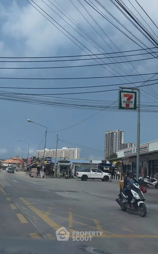 Street view with commercial buildings and residential high-rises in the background.