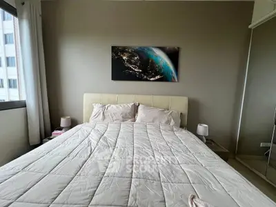 Cozy bedroom with modern decor and large window offering natural light.