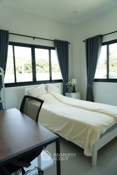 Bright bedroom with large windows and modern furnishings