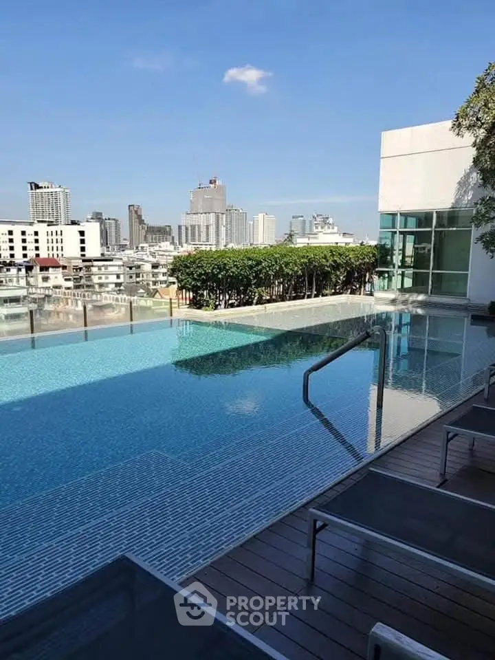 Luxurious rooftop infinity pool with stunning city skyline view, perfect for relaxation and leisure.