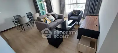 Modern living room with stylish furniture and dining area, featuring large windows and elegant decor.