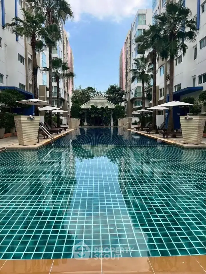 Luxurious apartment complex with stunning outdoor pool and palm trees, perfect for relaxation and leisure.