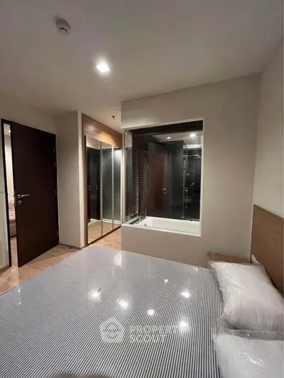 Modern bedroom with ensuite bathroom and mirrored closet doors, featuring sleek design and cozy ambiance.