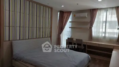 Spacious bedroom with modern decor and ample natural light, featuring a comfortable bed and stylish furnishings.