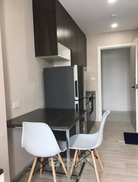 Modern kitchen with sleek cabinetry and dining area in a stylish apartment.