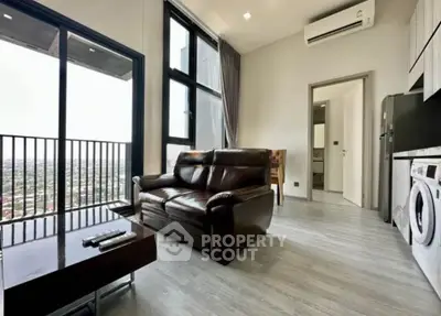 Modern living room with city view, featuring sleek furniture and integrated appliances.