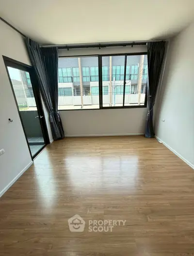 Spacious empty room with large windows and balcony access, perfect for customization.