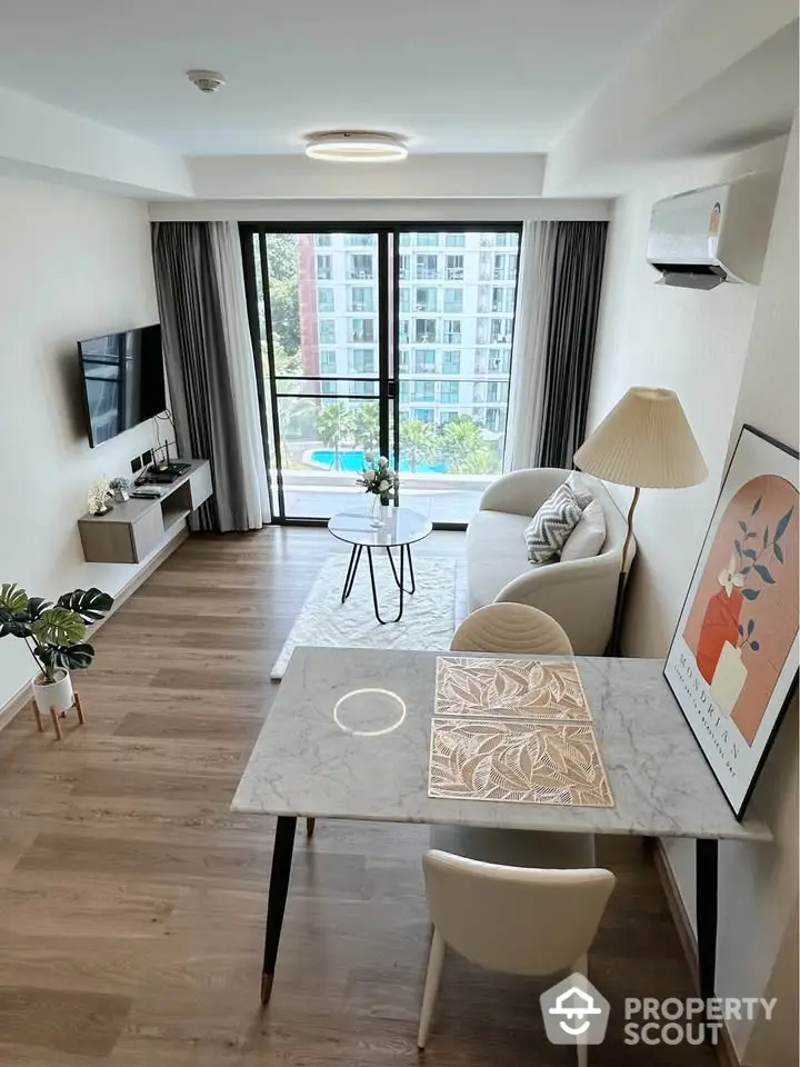 Modern living room with stylish decor and large windows offering a stunning view of the cityscape.