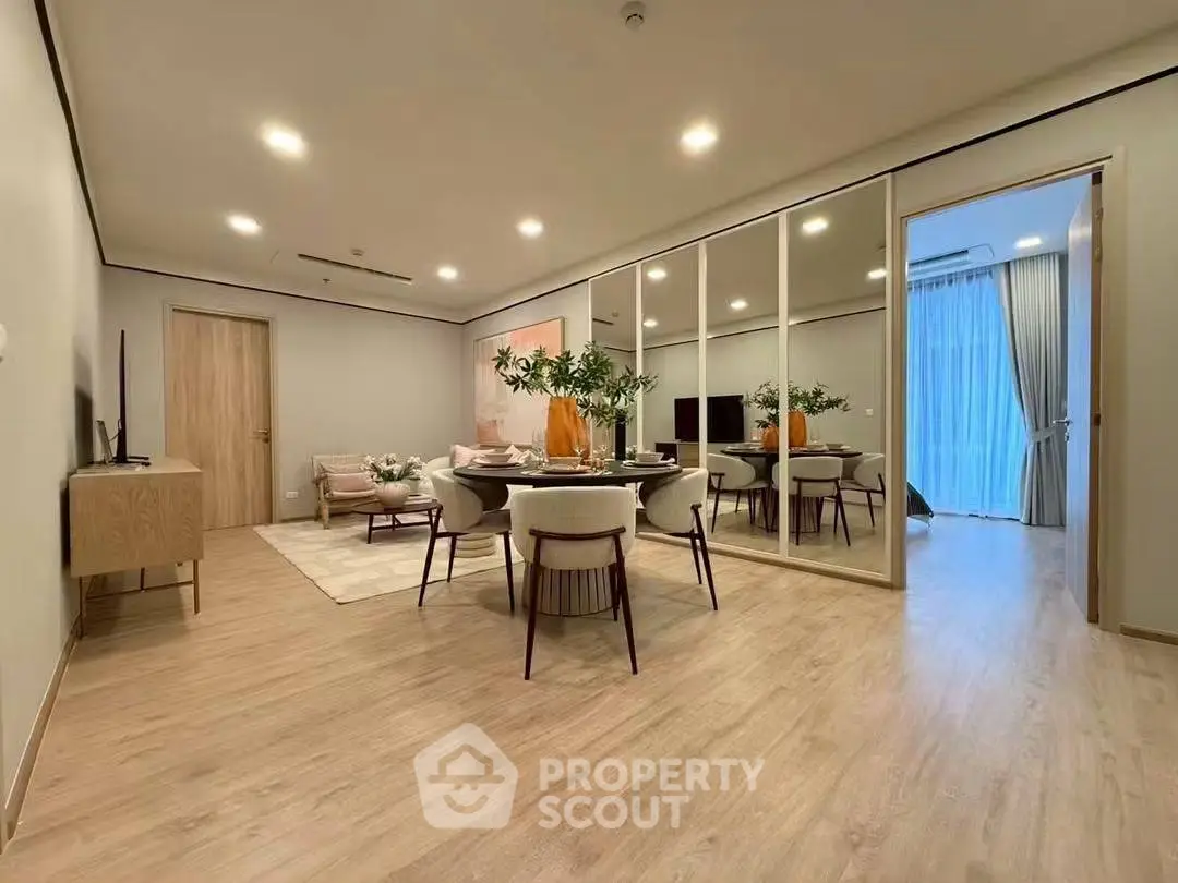 Spacious modern living room with elegant dining area and mirrored wall, perfect for stylish urban living.