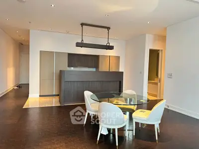 Modern open-plan living area with elegant dining set and stylish kitchen design.