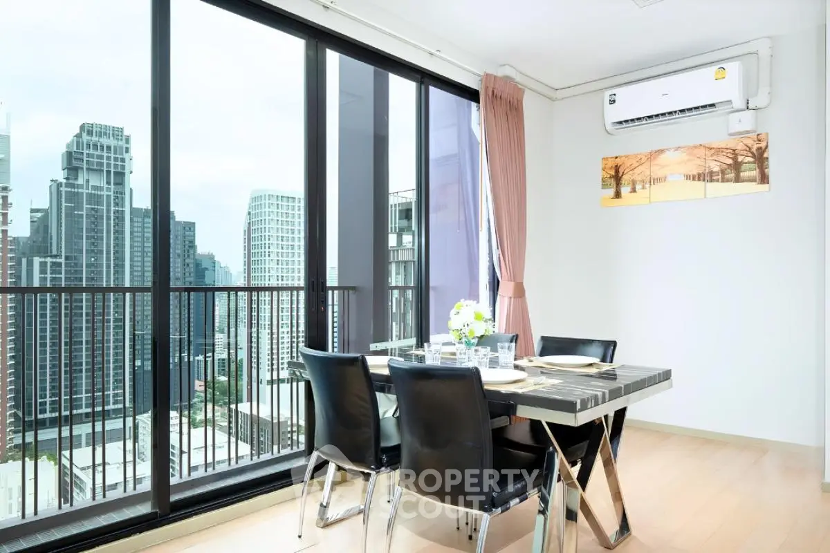 Modern dining area with stunning city view and floor-to-ceiling windows in a high-rise apartment.