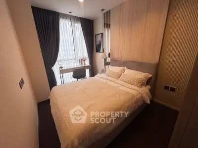 Cozy modern bedroom with elegant decor and large window for natural light.