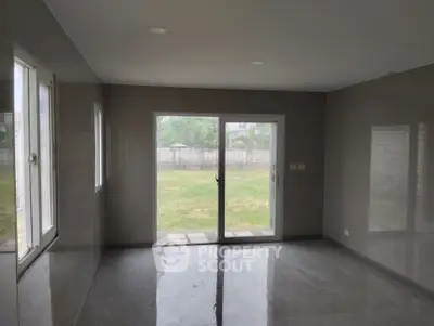 Spacious room with large windows and garden view, perfect for natural light and serene living.