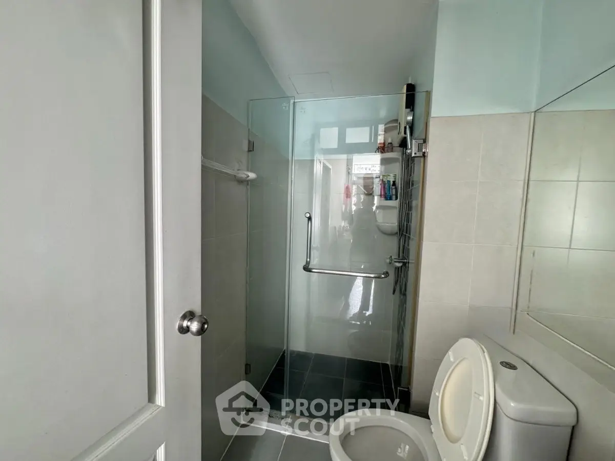 Modern bathroom with glass shower enclosure and tiled walls