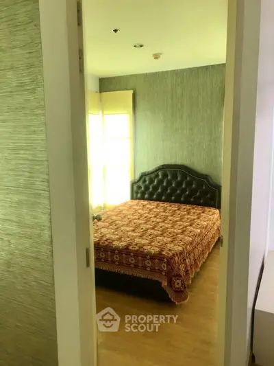 Cozy bedroom with elegant headboard and natural light, perfect for relaxation.