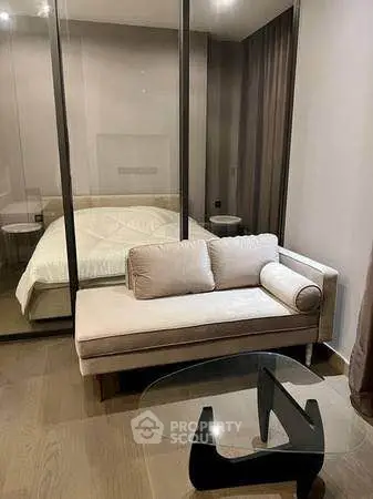 Modern bedroom with glass partition and cozy seating area