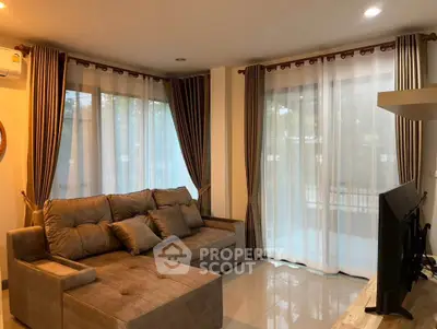Spacious living room with cozy sectional sofa and large windows for natural light.