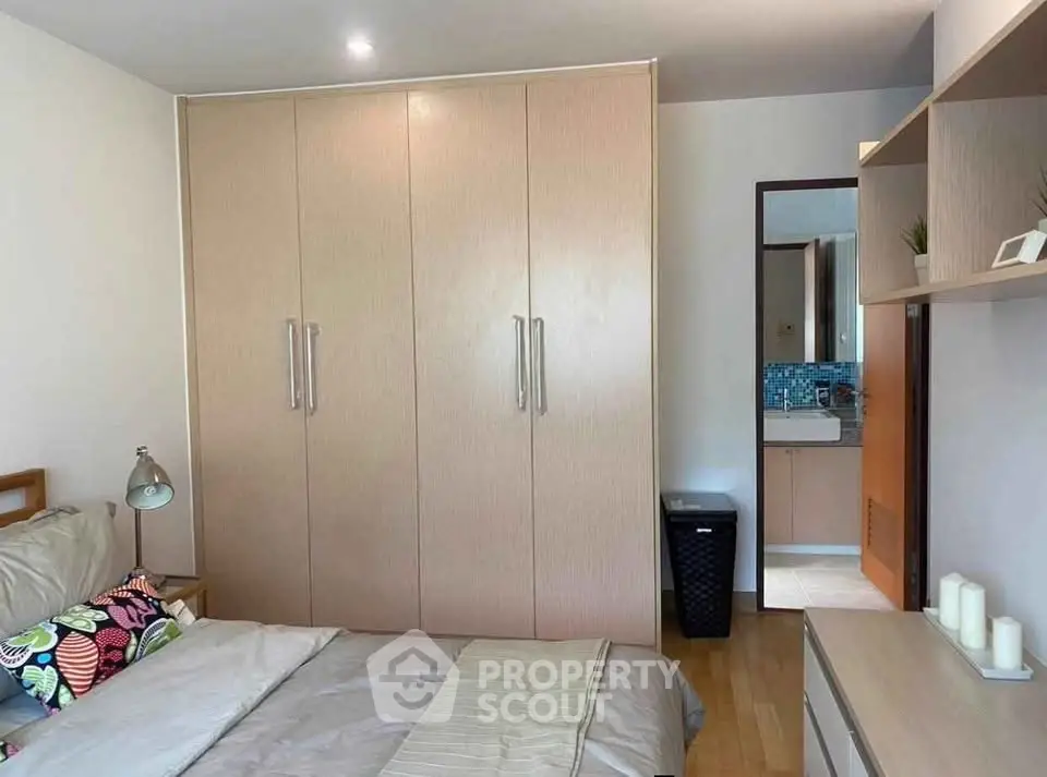 Cozy bedroom with built-in wardrobe and modern decor, perfect for comfortable living.