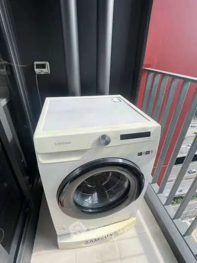 Modern washing machine on a balcony with city view, perfect for urban living convenience.
