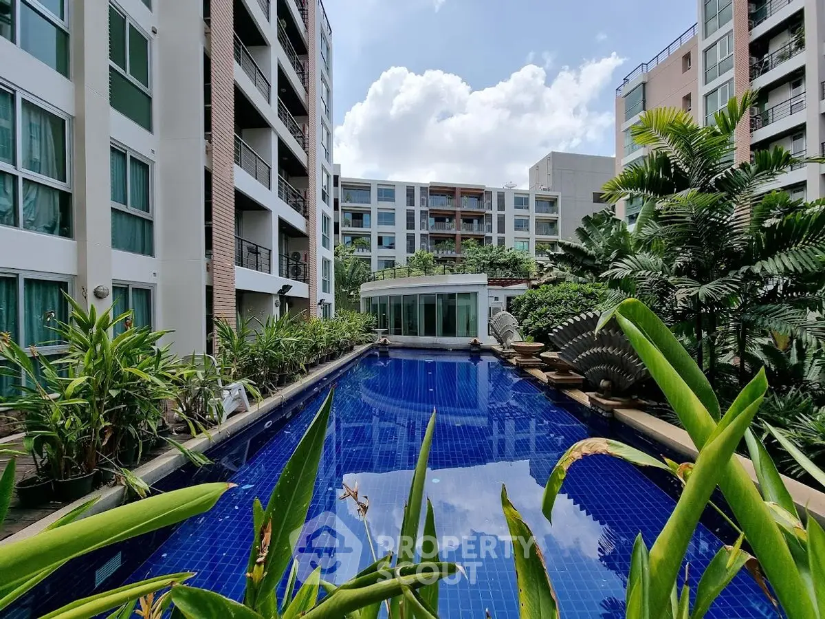Luxurious apartment complex with stunning pool and lush greenery