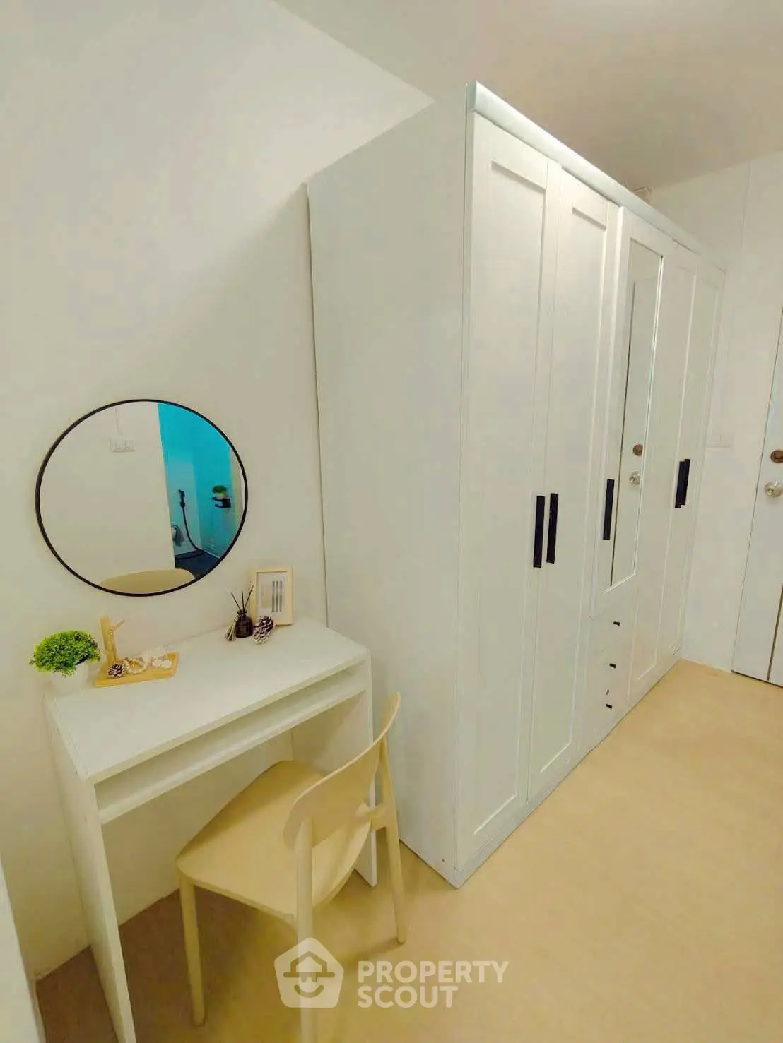 Chic bedroom corner with sleek white wardrobe and minimalist vanity desk, perfect for modern living.